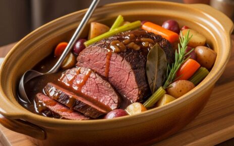 Tender slow-cooked beef chuck roast in a ceramic slow cooker with vegetables and rich brown gravy