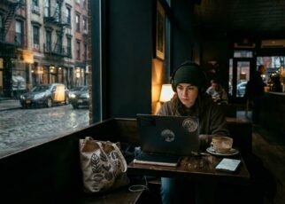 Freelancer working quietly in a late-night Manhattan cafe with laptop and coffee