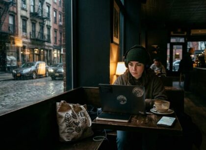 Freelancer working quietly in a late-night Manhattan cafe with laptop and coffee