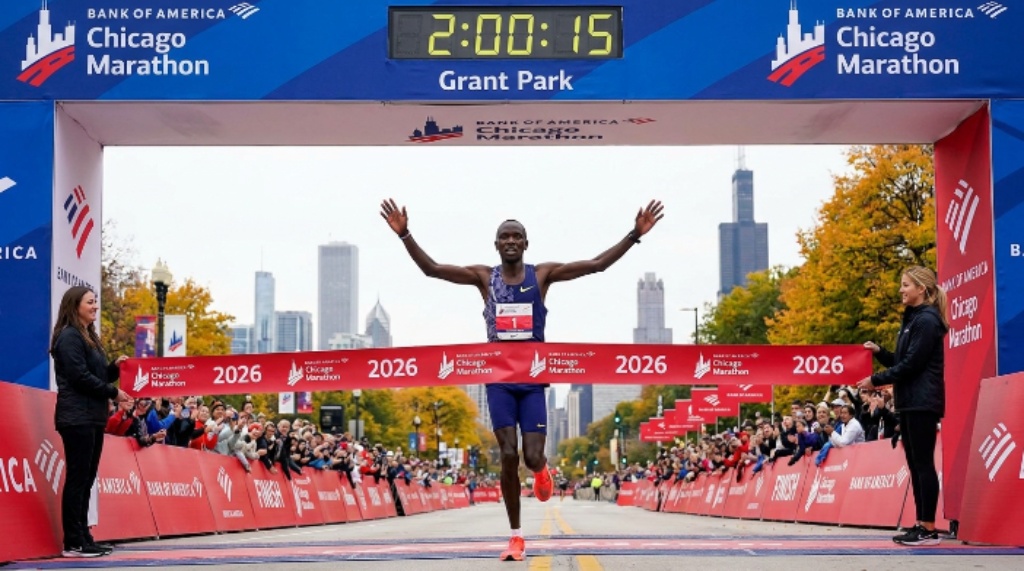 An elite runner crossing the finish line at the Bank of America Chicago Marathon 2026 in Grant Park, Chicago, with the city skyline in the background