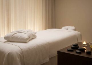 Therapist placing heated basalt stones on a client's back during massage