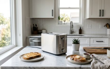 Sleek slim stainless steel toaster on a white marble countertop in a compact kitchen.