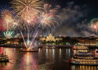 Fireworks bursting over the Mississippi River in New Orleans during New Year's Eve celebrations with St. Louis Cathedral in the background