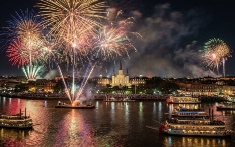 Fireworks bursting over the Mississippi River in New Orleans during New Year's Eve celebrations with St. Louis Cathedral in the background